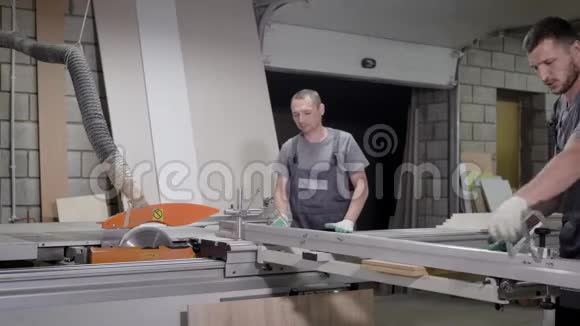 在木材切割机上工作的工人穿着制服视频的预览图