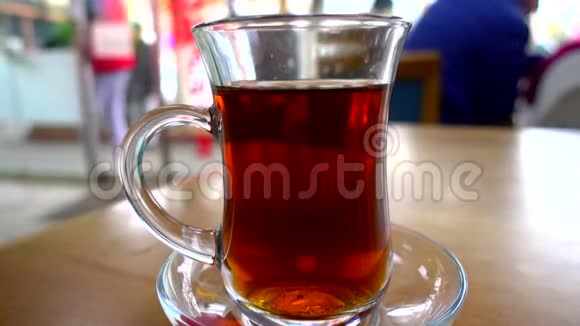 近景拍摄传统的土耳其茶杯在一家餐厅的餐桌上与人的背景视频的预览图