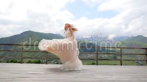 一位美丽的新娘在群山的背景下嬉戏玩耍视频的预览图