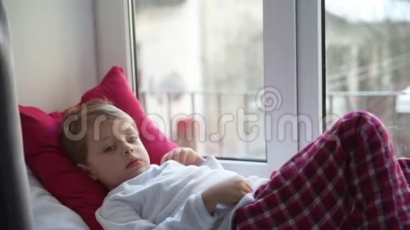从窗户向外张望的小男孩视频的预览图