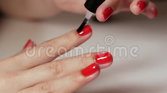 女性手指甲用红色指甲在白色背景上近距离观察经典的彩色美甲视频的预览图