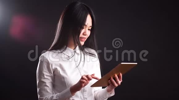 微笑年轻的亚洲妇女使用平板电脑电脑隔离在黑色背景视频的预览图