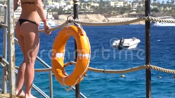 安全设备救生圈和女人臀部在海上背景上的木墩在海滩120fps视频的预览图