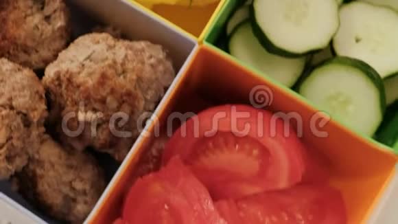 带细胞的午餐盒蔬菜黄瓜和西红柿煮土豆和肉饼视频的预览图