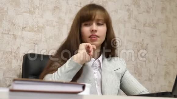 漂亮的女商人坐在办公室的椅子上在笔记本电脑和纸质文件上在线工作年轻女子视频的预览图