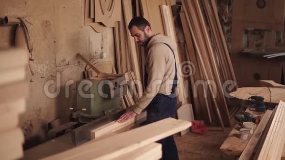 一个工匠用木头做电锯的侧视用手把木块冲过去视频的预览图