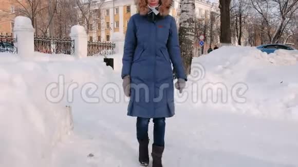 女人上了雪梯楼梯冬季公园在城市白天的雪天气与降雪视频的预览图