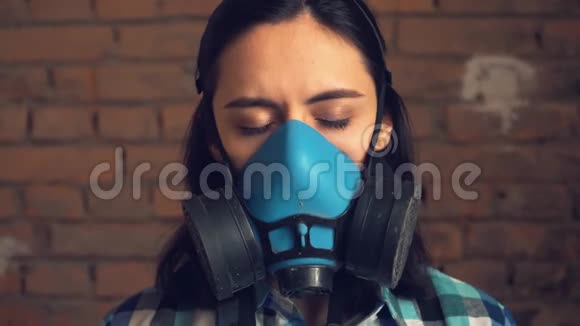 这个女孩从空气污染中摘下面具上砖墙背景呼吸面罩视频的预览图