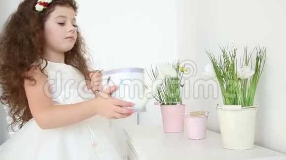 可爱的小女孩在家里用水缸跟踪镜头浇花视频的预览图