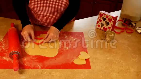 美味的自制情人节糖饼干是由祖母用爱卷和切出来的视频的预览图