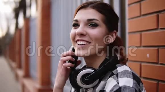 非常接近的镜头令人惊讶的是年轻女孩正在和朋友用手机交谈站在外面靠着视频的预览图