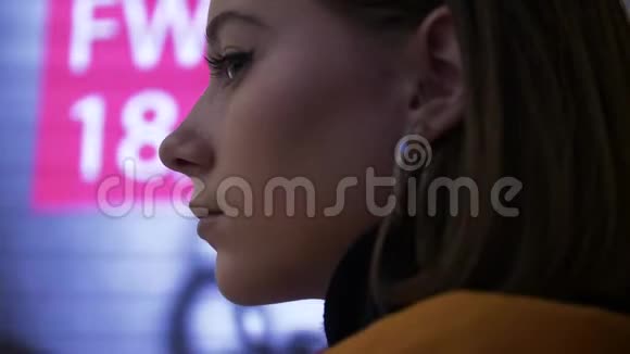 一个年轻模特在霓虹灯广告背景下的脸视频的预览图