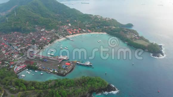 热带海滩和巴厘岛小镇有港口船只和蓝色海洋空中景观视频的预览图