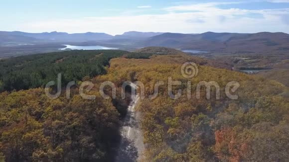 从空中俯瞰汽车在山上穿过森林秋天在美丽的山路上开车空中飞行视频的预览图