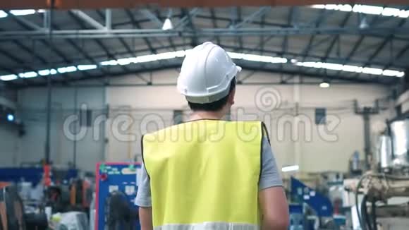 在工业设施中行走的工人戴安全安全帽视频的预览图