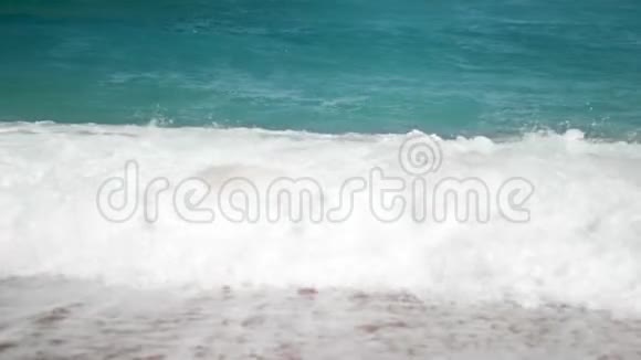 在阳光明媚的日子里强烈的绿松石海浪在海岸线上破浪前进视频的预览图