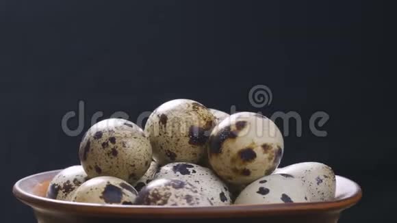 泥板上的鹌鹑卵在黑色背景上旋转概念健康食品饮食食品视频的预览图