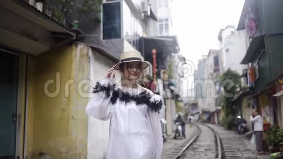 美丽而年轻的时尚美少女走在亚洲的街道与铁路之间的老建筑旅程视频的预览图