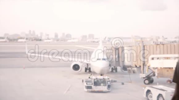 美丽的女性旅行者走到机场休息室候机楼窗口站起来欣赏路过飞机的景色视频的预览图