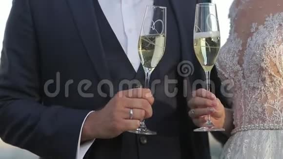 新郎和新娘站在城市的背景上喝着酒杯里的香槟克林克眼镜Hd视频视频的预览图