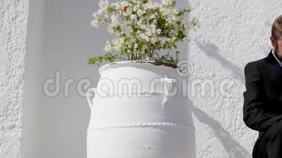 新婚夫妇新婚快乐背景是白色的墙花盆里放着鲜花视频的预览图