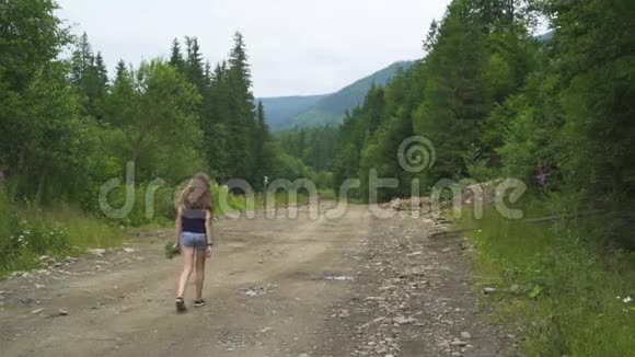 女孩带着浆果走在森林里的路上视频的预览图