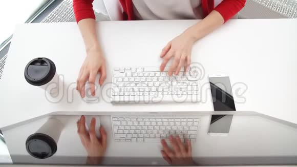 白色办公桌和女性电脑工作上景在键盘上打字视频的预览图