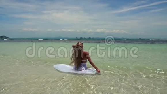 白裙浴在热带绿松石海的白裙女子视频的预览图