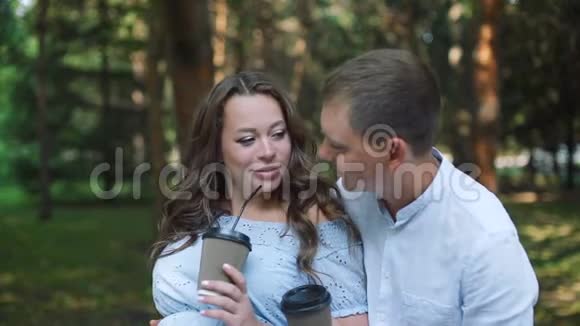 在公园喝杯茶的快乐孕妇夫妇视频的预览图