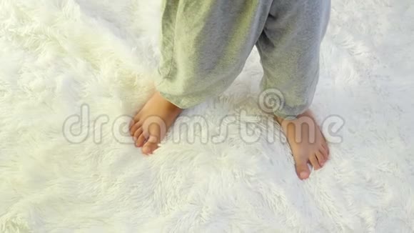婴儿的腿慢慢地铺在白色的地毯上视频的预览图