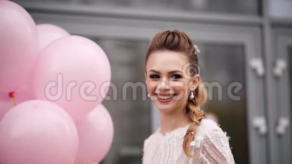 漂亮的年轻女孩头发花有粉红色的气球视频的预览图