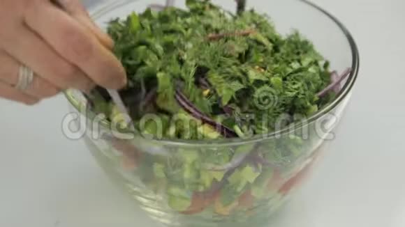 鲜沙拉与勺子和叉子混合的过程沙拉准备过程视频的预览图