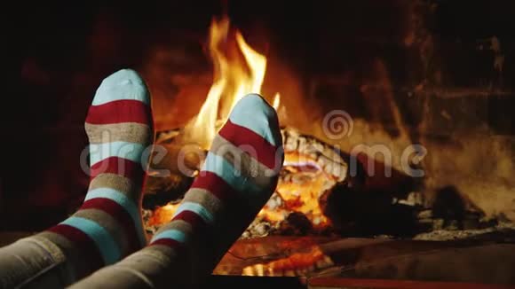 女孩在壁炉旁温暖了双脚视频的预览图