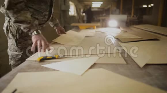 在家具车间工人用一把文具刀切割镶有单板的胶合条视频的预览图