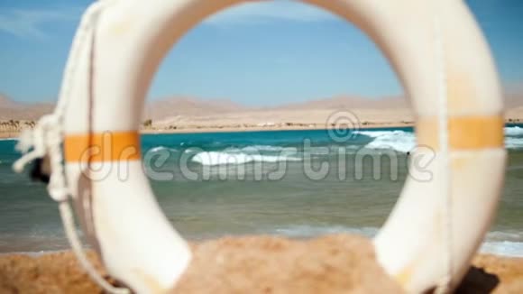 在阳光明媚的日子里平静的大海的特写镜头照相机透过救生圈浮标视频的预览图