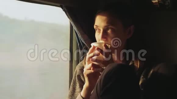 年轻女性一边在亚洲火车车窗外喝水视频的预览图