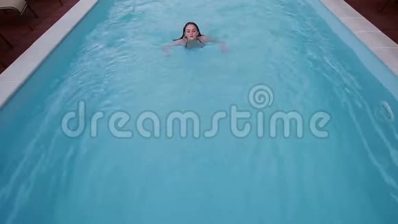 年轻女子正在游泳池游泳视频的预览图