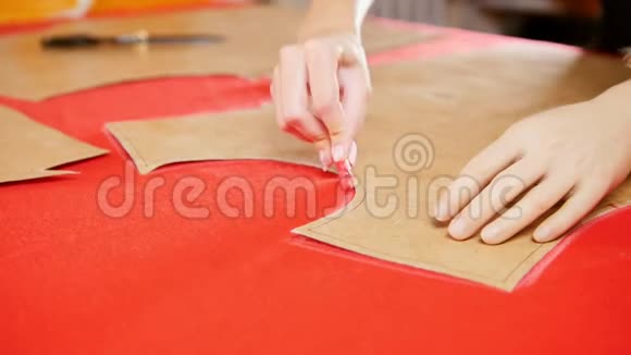 在缝纫厂用手臂假体在布上做草图的年轻女人双手集中视频的预览图