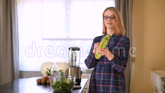 快乐的女人在厨房吃芹菜视频的预览图