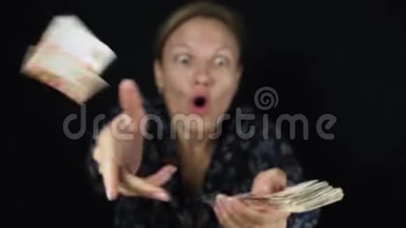 惊讶的女人在黑色背景上扔钞票五千卢布快乐的大堆钱慢动作股票视频的预览图