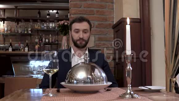 餐馆的客人坐在摄像机前面服务员打开餐具盖展示盘子高级餐厅视频的预览图