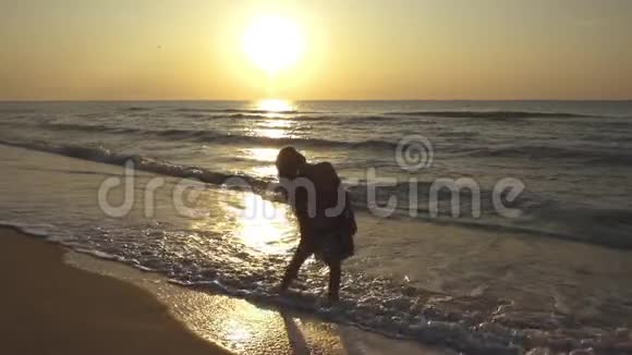 苗条的年轻女子正在日落时在海滩上跳舞视频的预览图