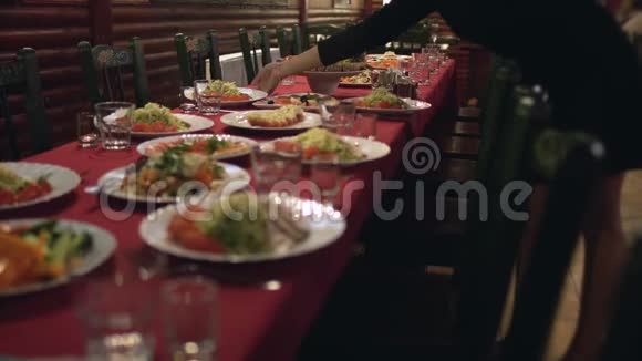 服务员把餐盘放在餐馆或咖啡馆的桌子上在宴会大厅里供应企业晚餐视频的预览图