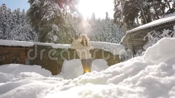 在早晨的阳光下穿着针织毛衣的迷人女孩的冬天肖像这个女孩享受着阳光明媚的霜冻早晨视频的预览图