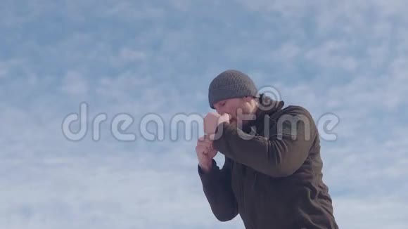 冬天拳击手在山上训练背景上的蓝天与阴影搏斗视频的预览图
