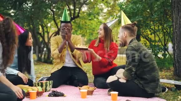 一个长胡子的非裔美国人在公园里开生日派对在蛋糕上吹蜡烛享受惊喜视频的预览图