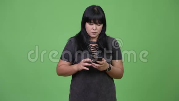 美丽超重的亚洲女人用电话看起来很震惊视频的预览图
