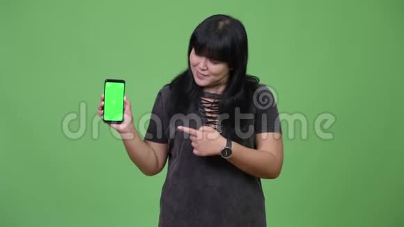 快乐超重的亚洲女人带着电话竖起大拇指视频的预览图