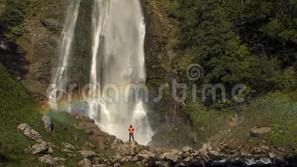 有彩虹的瀑布附近的徒步旅行者慢动作录像视频的预览图