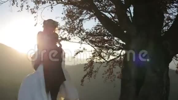 日落时分可爱的新婚夫妇新郎手里拿着新娘视频的预览图